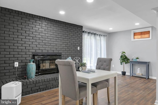 - dining room featuring wood finished floors, recessed lighting, and brick wall