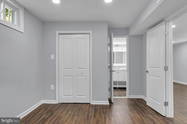 - unfurnished bedroom with dark wood-type flooring, a closet, recessed lighting, and ensuite bathroom