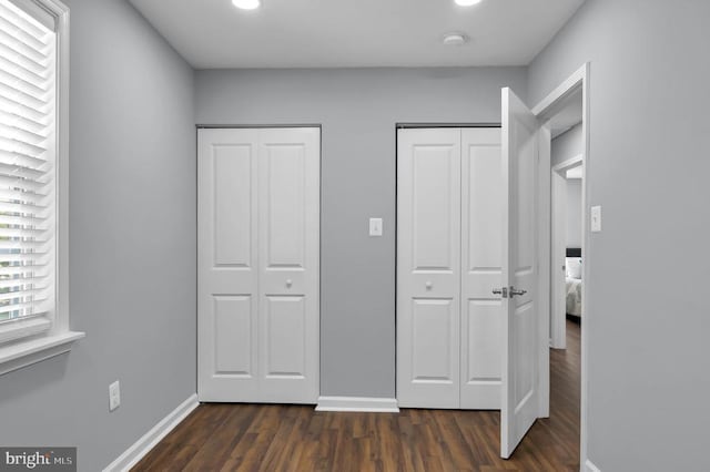  - unfurnished bedroom with multiple closets, dark wood-style floors, and recessed lighting