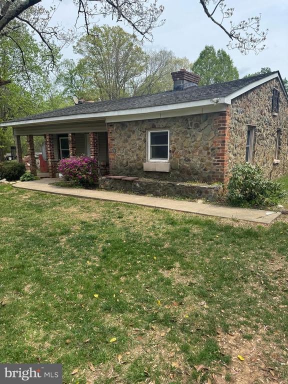 11418 Cox Ml, Gordonsville, VA 22942 - view of front of home featuring stone siding, a front yard, a chimney, and a porch