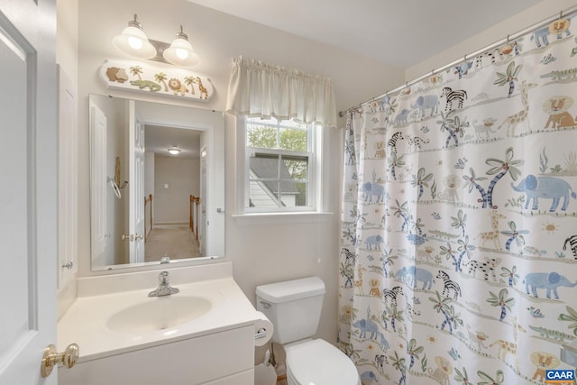 bathroom with toilet, a shower with shower curtain, and vanity