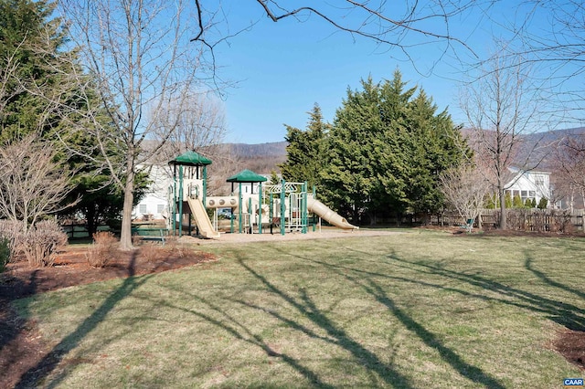view of yard featuring playground community and fence