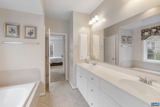 ensuite bathroom featuring double vanity, tile patterned floors, a bath, and a sink