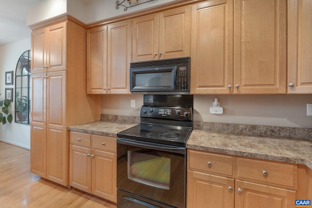 kitchen featuring black appliances, light wood-style floors, and light brown cabinetry