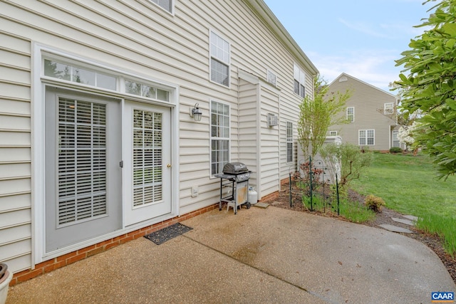 doorway to property featuring a patio and a lawn