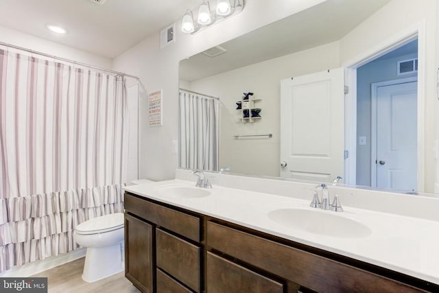 bathroom featuring a sink, toilet, and visible vents