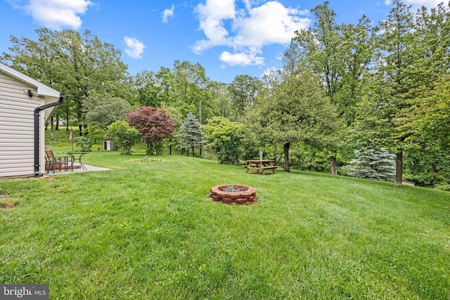  - view of green lawn featuring an outdoor fire pit and a patio area