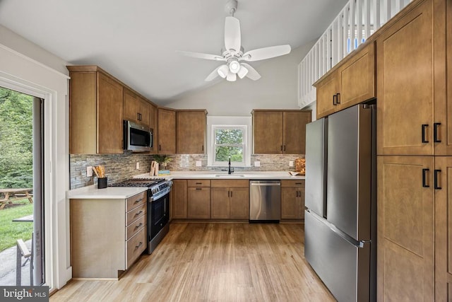  - kitchen featuring appliances with stainless steel finishes, light wood-style flooring, backsplash, ceiling fan, and brown cabinets