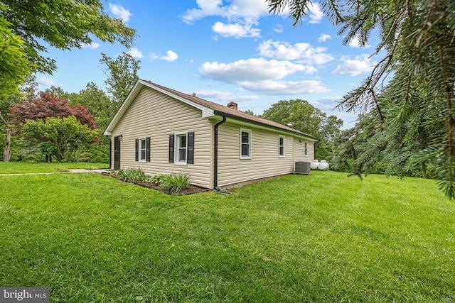  - view of side of home with a yard and a chimney
