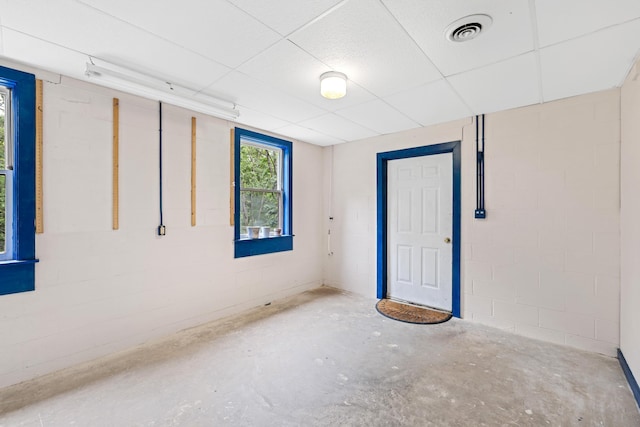 409 Thomas St, Staunton, VA 24401 - empty room featuring unfinished concrete floors, concrete block wall, and a paneled ceiling