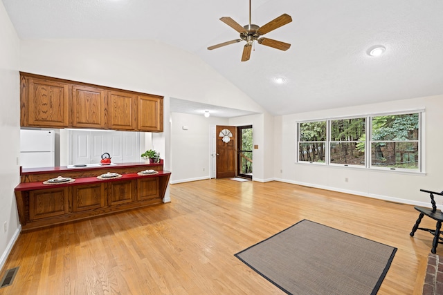 409 Thomas St, Staunton, VA 24401 - kitchen with freestanding refrigerator, ceiling fan, vaulted ceiling, brown cabinets, and light wood-style flooring