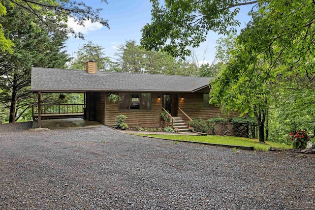 409 Thomas St, Staunton, VA 24401 - view of front facade with a chimney, gravel driveway, a carport, and a shingled roof