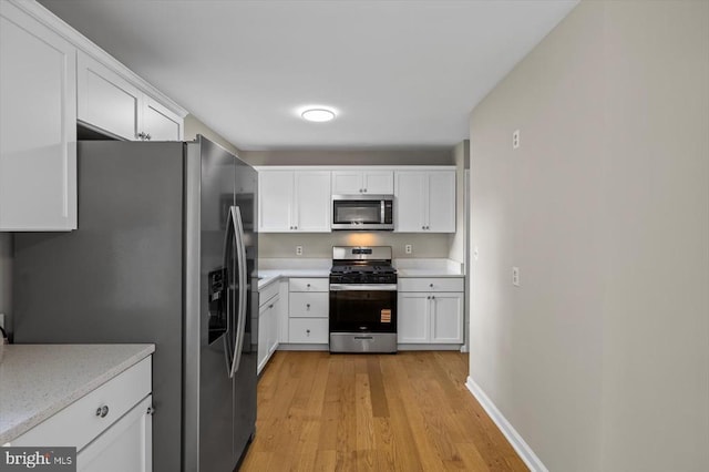 809 Sherwood Ln, Fredericksburg, VA 22407 - kitchen featuring stainless steel appliances, light wood-style flooring, white cabinets, and light countertops