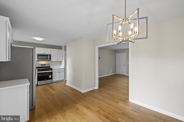809 Sherwood Ln, Fredericksburg, VA 22407 - kitchen featuring appliances with stainless steel finishes, white cabinets, light wood finished floors, and light countertops
