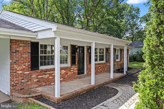 809 Sherwood Ln, Fredericksburg, VA 22407 - view of exterior entry featuring a porch, brick siding, and roof with shingles