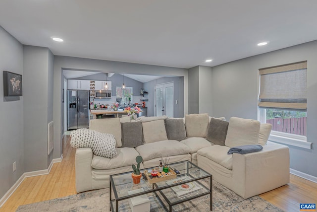 living area featuring light wood-style flooring, baseboards, plenty of natural light, and recessed lighting