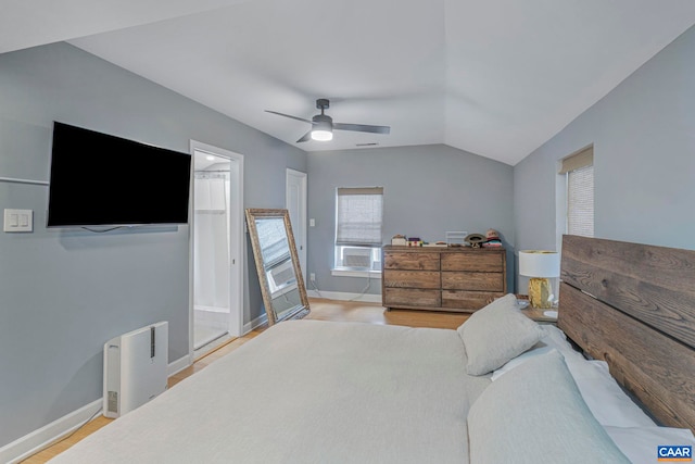 bedroom featuring lofted ceiling, baseboards, light wood finished floors, cooling unit, and ceiling fan