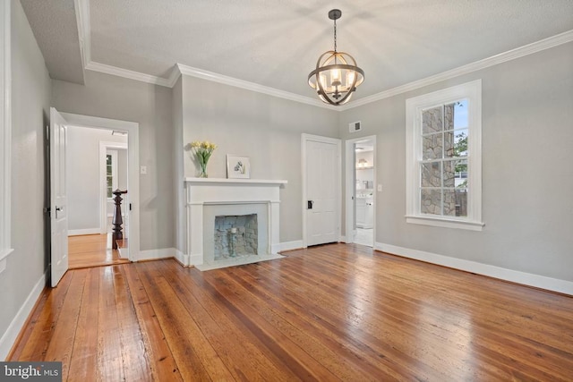 105 Washington St E, Remington, VA 22734 - unfurnished living room with wood-type flooring, a chandelier, a fireplace with flush hearth, and crown molding