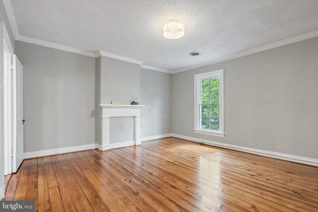 105 Washington St E, Remington, VA 22734 - unfurnished living room featuring wood-type flooring, ornamental molding, a textured ceiling, and a fireplace