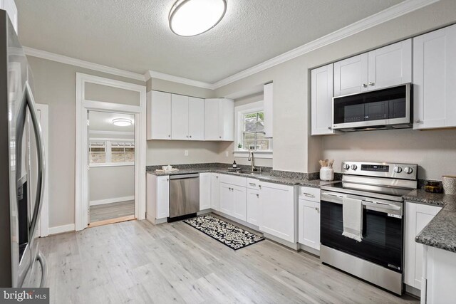 105 Washington St E, Remington, VA 22734 - kitchen with stainless steel appliances, a textured ceiling, white cabinets, light wood finished floors, and ornamental molding