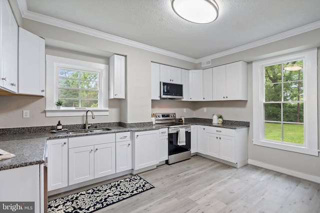 105 Washington St E, Remington, VA 22734 - kitchen featuring appliances with stainless steel finishes, a textured ceiling, light wood finished floors, white cabinets, and ornamental molding