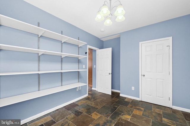  - unfurnished bedroom with stone tile floors and a chandelier