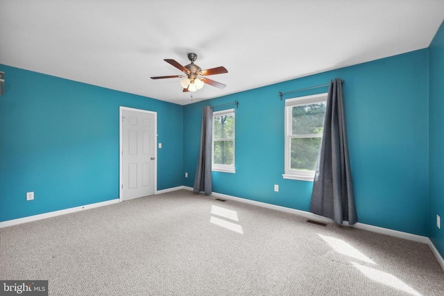  - carpeted spare room with ceiling fan and baseboards