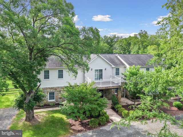 - view of front of property with stone siding and a wooden deck