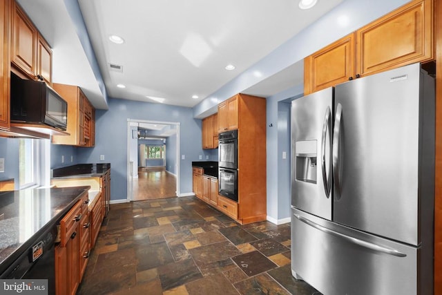  - kitchen with black appliances, dark stone finish flooring, brown cabinetry, recessed lighting, and dark stone counters