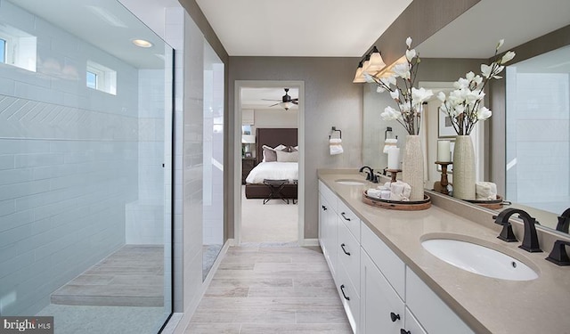 full bath with a ceiling fan, double vanity, ensuite bathroom, and tiled shower