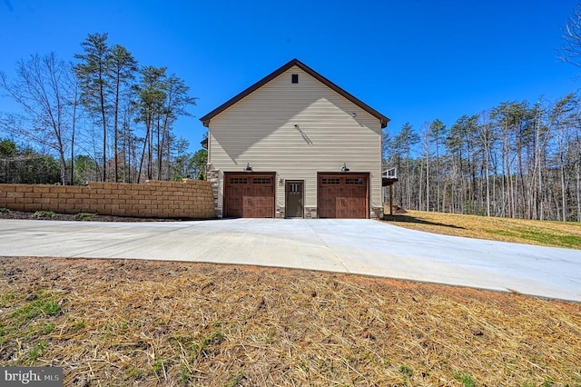view of side of property featuring an attached garage and driveway