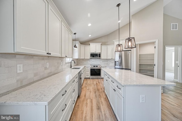 kitchen featuring a sink, stainless steel appliances, visible vents, light wood finished floors, and white cabinetry