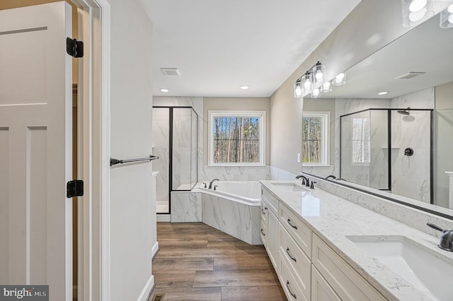 full bath with a garden tub, a marble finish shower, visible vents, and a sink