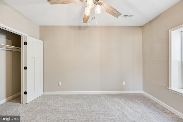 unfurnished bedroom featuring a ceiling fan, carpet floors, baseboards, and visible vents
