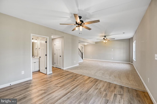 unfurnished living room featuring baseboards and a ceiling fan