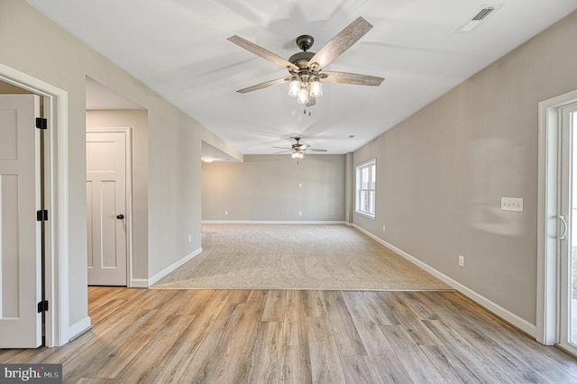 spare room with visible vents, light wood-style flooring, baseboards, and ceiling fan