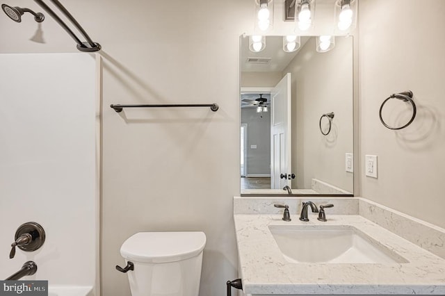 bathroom featuring toilet, vanity, visible vents, and shower / bathing tub combination