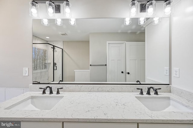full bathroom featuring vanity, a shower stall, and visible vents