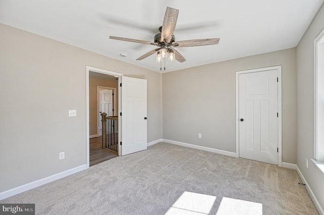unfurnished bedroom with carpet floors, baseboards, and a ceiling fan