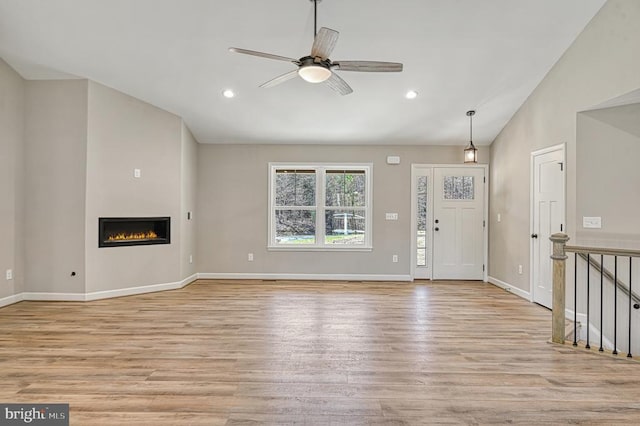 unfurnished living room featuring a ceiling fan, light wood-style floors, recessed lighting, and vaulted ceiling