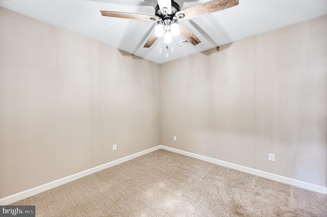 spare room featuring carpet flooring, visible vents, baseboards, and ceiling fan