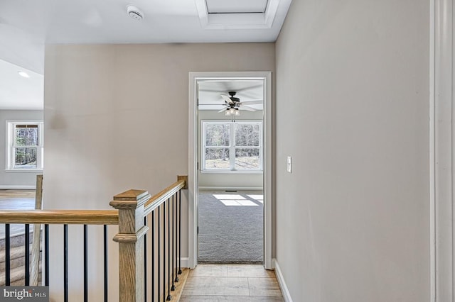 corridor with baseboards and an upstairs landing