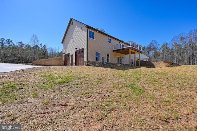 view of home's exterior with a wooden deck, an attached garage, and stone siding