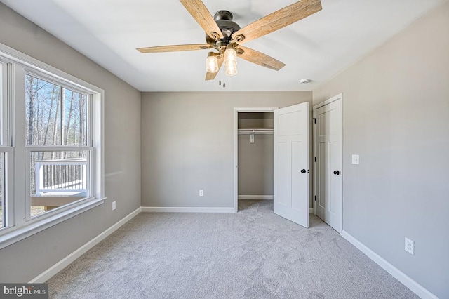 unfurnished bedroom featuring carpet, a closet, baseboards, and a ceiling fan