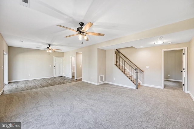 unfurnished living room featuring carpet, baseboards, visible vents, ceiling fan, and stairs