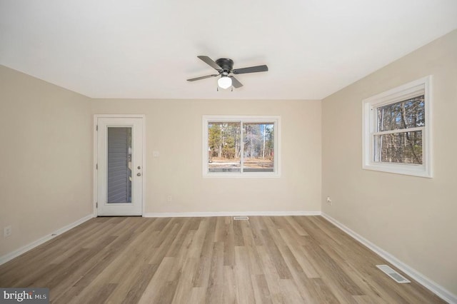 spare room with ceiling fan, baseboards, and light wood-style flooring