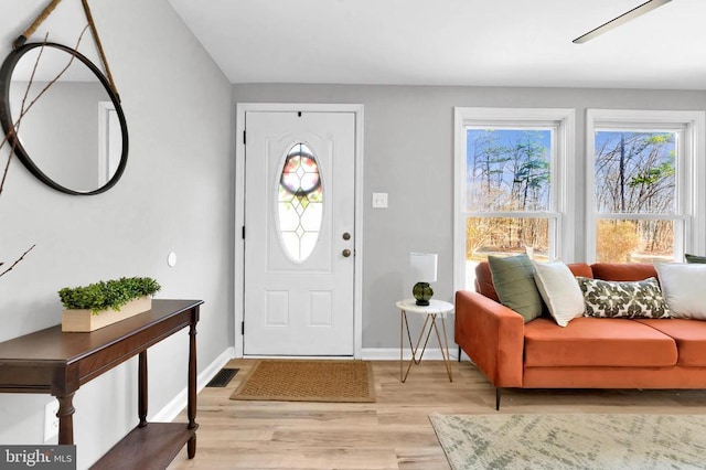 foyer featuring light wood-type flooring, visible vents, and baseboards