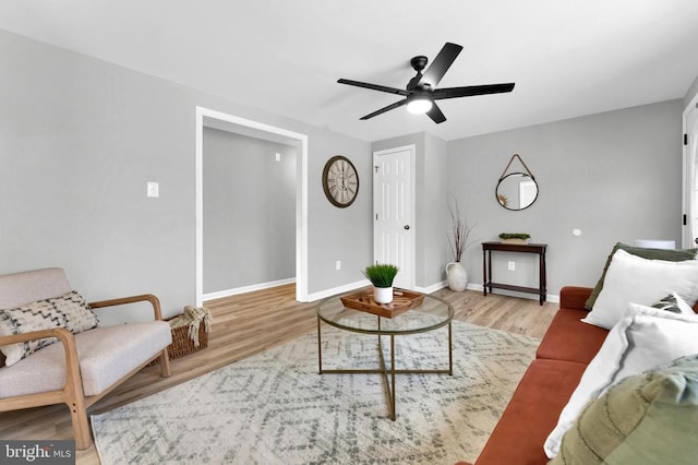 living area with ceiling fan, wood finished floors, and baseboards