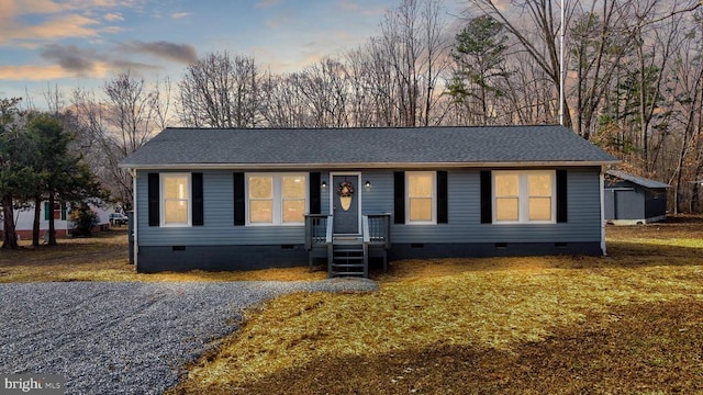 view of front facade featuring crawl space and roof with shingles