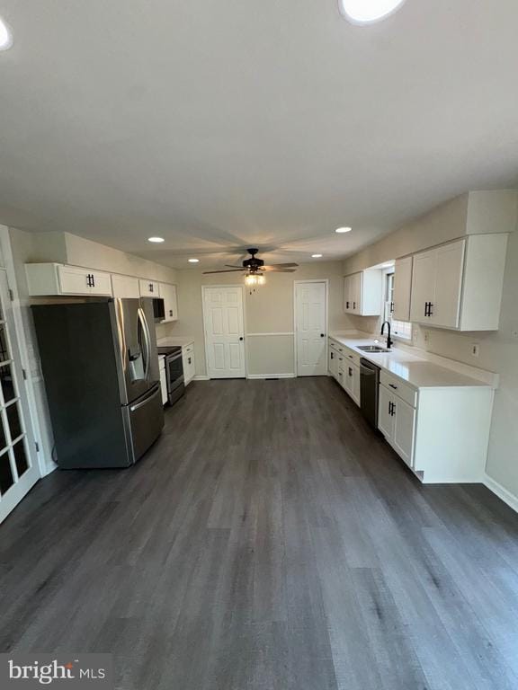 12704 Getty Ln, Spotsylvania, VA 22551 - kitchen with appliances with stainless steel finishes, ceiling fan, dark wood-style flooring, white cabinetry, and light countertops